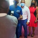 Lloyd Allen, ZNS reporter, interviews Stephen Dean, President, RCN as Jamal Davis, Community Service Director, RCN and Maxine V. Seymour, Director, Corporate Communications, Colina Insurance Limited look on