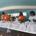 (l to r): Sandra Thomas, Manager, Claims and Administration and Francine Dames, Claims Adjudicator, Colina Insurance Limited packing food parcels with a team member from The Bahamas Feeding Network. AHVIA J. CAMPBELL