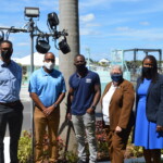 (l to r) Marcus Bosland, Resident Actuary, Colina; Dwayne Gibson, Chairman, Board of Directors, R.E.A.C.H.; Chad Gibson, CEO, Hype Lightz; Marcia Newball, Board Member, R.E.A.C.H; Maxine
Seymour, Director, Corporate Communications, Colina stand in front of some of the lights that have been installed at 308 East Bay Street to provide blue illumination during the month.