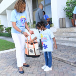 Chantal A. Horton, Communications Officer, Colina and little Miss Hepburn select the winner of $75 gas voucher. The Company held a raffle for staff members who purchased autism awareness t-shirts