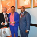 Philip Smallwood, Director of Sales (l) and Kino McCartney, Branch Manager (r) present Aisha Lightbourn with her award.