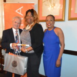 Deone Wilson (center) glowing with her new designation in hand, presented by Philip Smallwood, Director of Sales and Yvonne Gibson-Sands, Sales Manager.