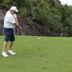 Richard King takes a swing at the golf tournament.
