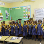 Sapna Chatlini, VP, Group & Health Benefits Department with Grade 2 students and their teacher.