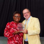 Vernis is all smiles as she receives her award from Chief Executive Officer, Emanuel Alexiou.