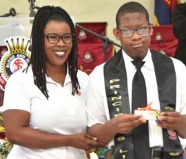 Maxine V. Seymour, director of corporate communications at Colina, presents Kamall Forbes with a gift.