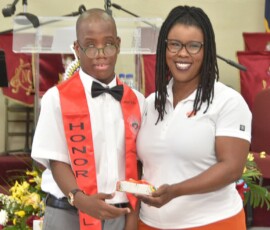 Kylan Cartwright smiles as he receives a gift from Maxine V. Seymour, director of corporate communications at Colina.