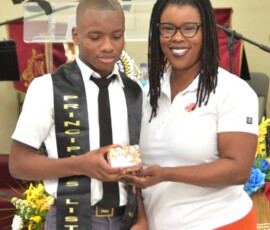 Quintino Barr is acknowledged for his achievement by Maxine V. Seymour, director of corporate communications at Colina.
